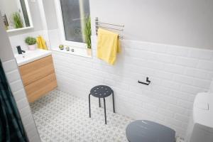 a bathroom with a toilet and a sink and a stool at 3 Rooms Apartment In Budapest in Budapest