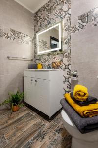 a bathroom with a sink and a toilet and a mirror at Best Guest 2 Apartments in Plovdiv