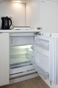 an empty refrigerator with its door open in a kitchen at Cosy studio centre Versailles in Versailles