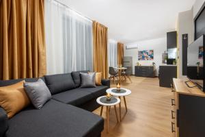 a living room with a couch and a tv at Best Guest 2 Apartments in Plovdiv
