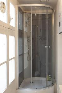 a shower with a glass door in a bathroom at Cosy studio centre Versailles in Versailles