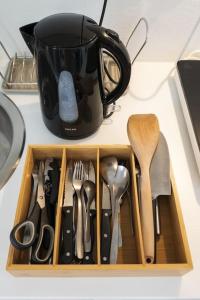 a drawer filled with utensils and a coffee mug at Cosy studio centre Versailles in Versailles
