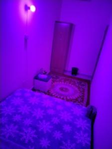 a purple bedroom with a bed with a pink light at My Home Stay apartment 2 in Abu Dhabi