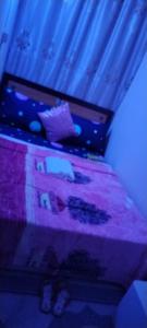 a bedroom with a bed with a purple blanket at My Home Stay apartment 2 in Abu Dhabi