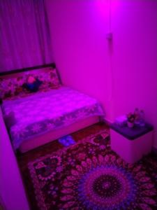 a pink room with a bed and a table at My Home Stay apartment 2 in Abu Dhabi