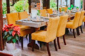 een lange tafel met gele stoelen en glazen erop bij Quinta Los Juanes in Baños