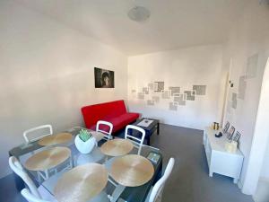 een kamer met een tafel en stoelen en een rode bank bij Giulia home in Monfalcone