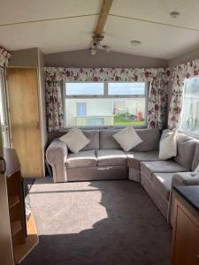 uma sala de estar com um sofá e uma janela em Two bedroom Caravan with Sea Views, Warden Springs Eastchurch em Warden