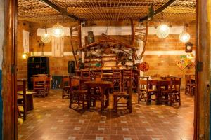 um restaurante com mesas e cadeiras de madeira numa sala em Hotel Arqueológico San Agustín em San Agustín