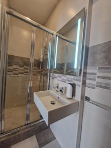 y baño con lavabo y ducha. en KORZO SUITES SLIEMA II, en Sliema