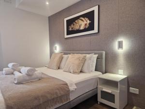 1 dormitorio con 1 cama con sábanas y almohadas blancas en KORZO SUITES SLIEMA II, en Sliema