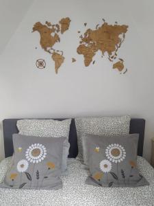 um mapa do mundo numa parede com almofadas em duplex de charme à Dinan em Taden