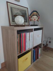 uma estante cheia de livros e uma estátua em duplex de charme à Dinan em Taden