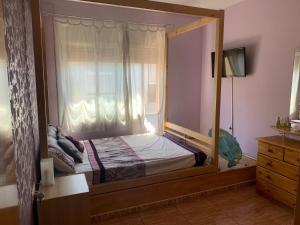 1 dormitorio con cama con dosel y ventana en Apartamento Bàsico, en Cala Llonga