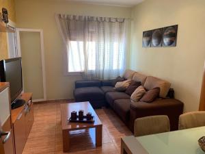 sala de estar con sofá y mesa en Apartamento Bàsico, en Cala Llonga