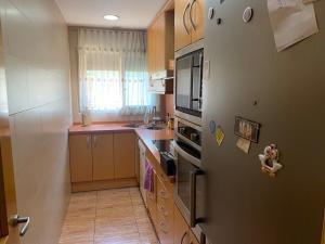 una pequeña cocina con nevera y fregadero en Apartamento Bàsico, en Cala Llonga