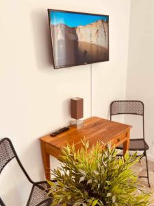 Cette chambre dispose d'une table en bois et d'une télévision murale. dans l'établissement Studio 7 EDEN, à Saint-Tropez