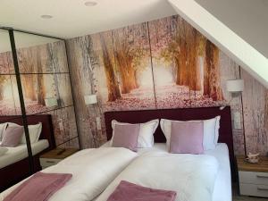 a bedroom with two beds and a painting on the wall at Holidayhaus Lütsche in Frankenhain