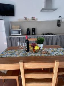 una mesa con una botella de vino y fruta. en Apartamento en Mala Las Mercedes, en Mala