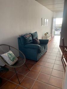 sala de estar con sofá azul y mesa en Apartamento en Mala Las Mercedes, en Mala