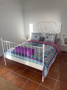 Un dormitorio con una cama blanca con sábanas y almohadas moradas en Apartamento en Mala Las Mercedes, en Mala