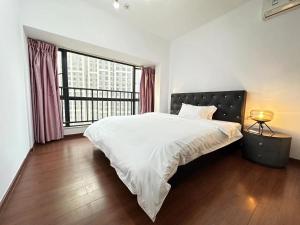a bedroom with a large bed and a large window at Guangzhou Phantom Oasis Apartments - Canton Fair Exhibition Area in Guangzhou