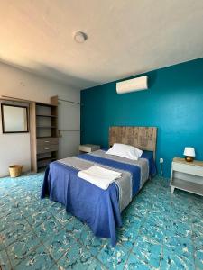 a bedroom with a bed with a blue wall at The FLORENTHINA'S House in Oaxaca City