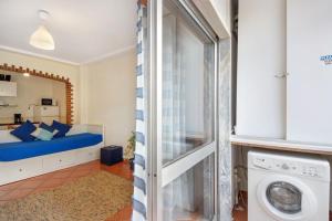 a room with a bed and a washing machine at Manny's place - by the sea in Gafanha da Nazaré