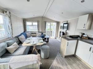 a living room with a couch and a table at Drakes View Dog friendly chalet in South Cerney