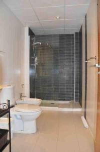 a bathroom with a toilet and a glass shower at Ibo beach apartment Albir in Albir