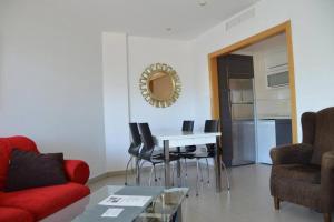a living room with a red couch and a table at Ibo beach apartment Albir in Albir
