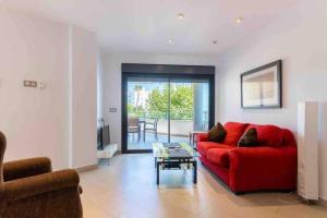 a living room with a red couch and a table at Ibo beach apartment Albir in Albir