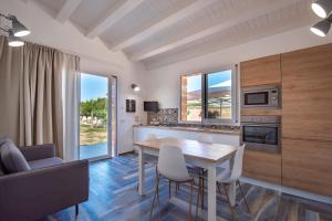 a kitchen and dining room with a table and chairs at Villa del Papiro Charme Apartments in Avola