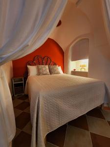 a bedroom with a large bed with an orange headboard at Casa Venturo in Minori