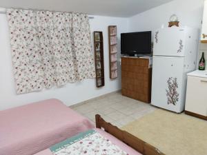 a living room with a refrigerator and a tv at Mountain Top Eleochori Βουνοκορφή in Elaiokhórion