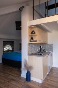 una cocina con fregadero y una cama en una habitación en B&B De Joker, en Turnhout