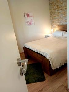 sypialnia z łóżkiem i ceglaną ścianą w obiekcie Apartment Maro w Szybeniku