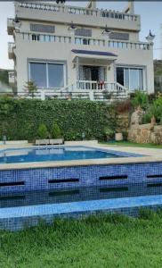 a house with a swimming pool in front of a house at La Perla Montaña Tanger in Tangier