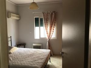 Schlafzimmer mit einem Bett und einem Fenster in der Unterkunft Palaio Faliro Plaza με Jacuzzi και Τζάκι in Athen