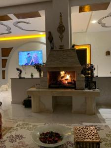 sala de estar con chimenea y TV en La Perla Montaña Tanger en Tánger