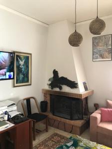 ein Wohnzimmer mit einem Kamin und einem Schreibtisch in der Unterkunft Palaio Faliro Plaza με Jacuzzi και Τζάκι in Athen
