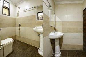 uma casa de banho com um lavatório e um WC em Hotel King Plaza em Nova Deli