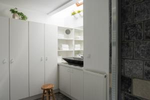 una cucina con mobili bianchi e un muro di mattoni di B&B De Joker a Turnhout