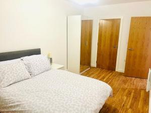 吉林漢姆的住宿－A Cosy 2bedroom Apartment With River View，卧室配有一张白色大床,铺有木地板