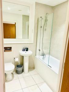 a bathroom with a sink and a toilet and a shower at A Cosy 2bedroom Apartment With River View in Gillingham