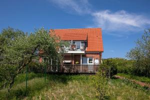 a house with an orange roof on a hill at Haus Delphin in Juist