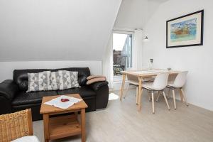 a living room with a black couch and a table at Haus Delphin in Juist