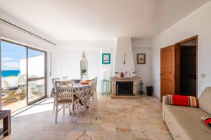 een woonkamer met een tafel en uitzicht op de oceaan bij Casa Cerro Branco in Albufeira