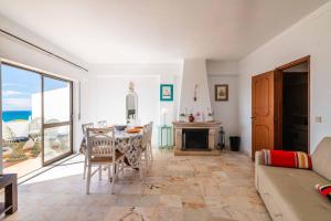 a living room with a table and a view of the ocean at Casa Cerro Branco in Albufeira