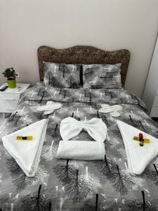 Una cama con toallas blancas y colcha. en URAZ Suit Otel, en Bursa